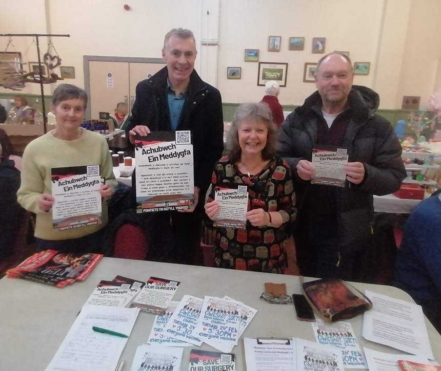 Group of campaigners holding Save Our Surgery leaflets at a community event in Pontyates.