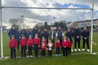 Schoolchildren and Ospreys players together on rugby pitch at St Helens Swansea during community rugby announcement