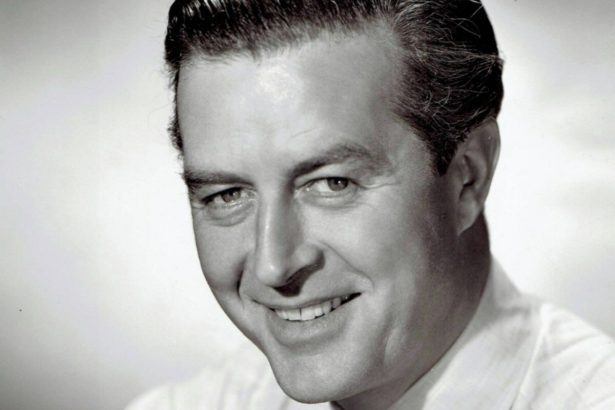A black and white studio headshot of a smiling Ray Milland from the 1940s, wearing a white shirt and striped tie.