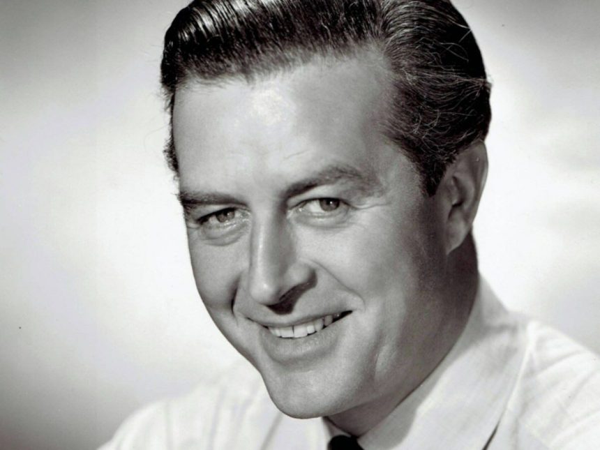 A black and white studio headshot of a smiling Ray Milland from the 1940s, wearing a white shirt and striped tie.