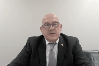 WRU Chair Richard Collier-Keywood, wearing a dark suit and grey tie with a gold WRU pin badge, speaks via video link to the Senedd committee.