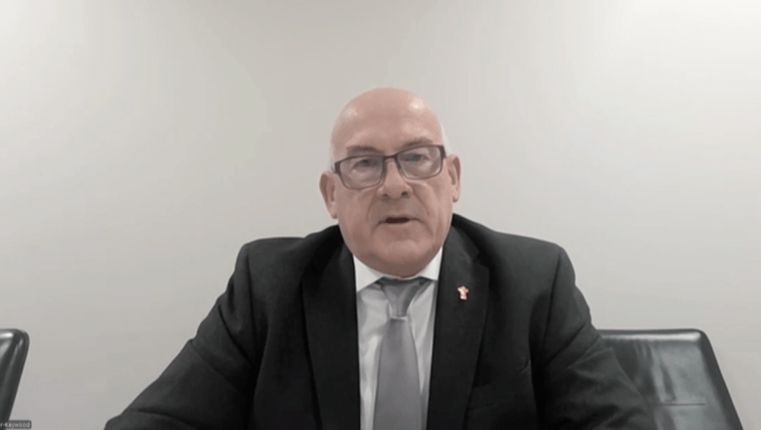 WRU Chair Richard Collier-Keywood, wearing a dark suit and grey tie with a gold WRU pin badge, speaks via video link to the Senedd committee.