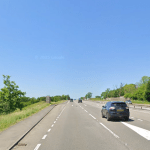 A Google Street View image of the A48 dual carriageway near Llanddarog, Carmarthenshire, showing a lay-by on the left-hand side of the westbound carriageway, lined with trees and shrubs.
