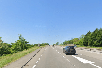 A Google Street View image of the A48 dual carriageway near Llanddarog, Carmarthenshire, showing a lay-by on the left-hand side of the westbound carriageway, lined with trees and shrubs.