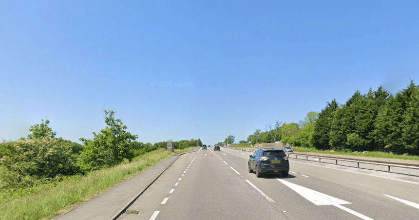 A Google Street View image of the A48 dual carriageway near Llanddarog, Carmarthenshire, showing a lay-by on the left-hand side of the westbound carriageway, lined with trees and shrubs.