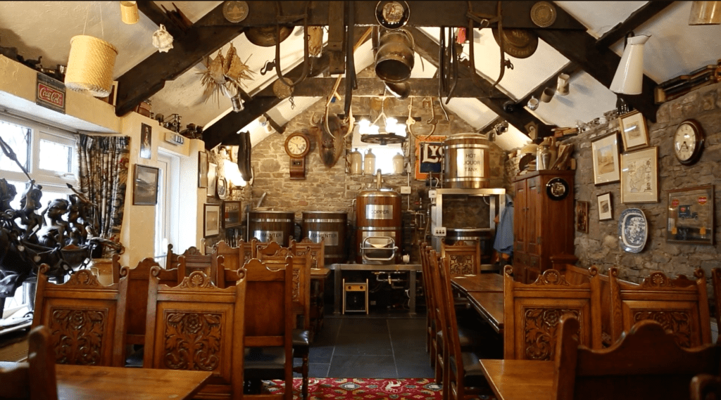 Traditional pub dining room with wooden furniture and brewing equipment on display