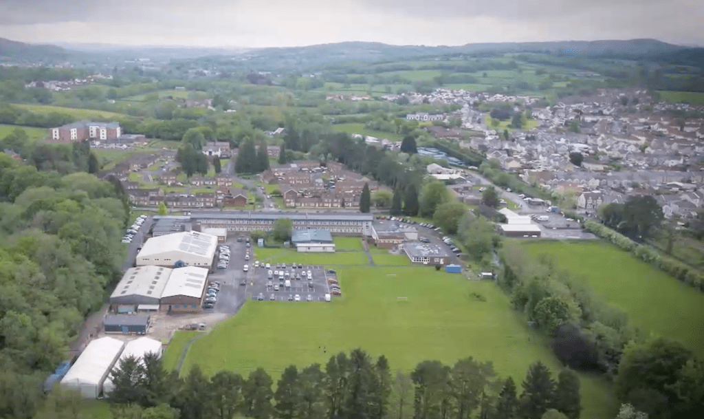 Aerial view of Coleg Sir Gar Ammanford campus showing buildings, sports and surrounding town