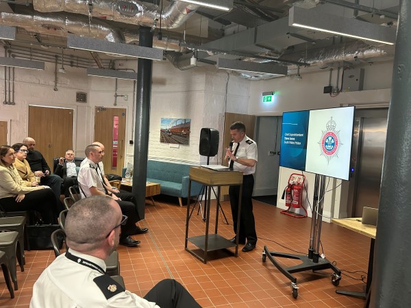 Police officer speaking at a podium during the Dyfatty Clear Hold Build launch event