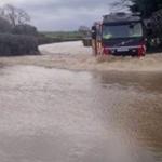 Vehicle driving through deep floodwater on the A4118 near Scurlage in Gower during severe flooding.