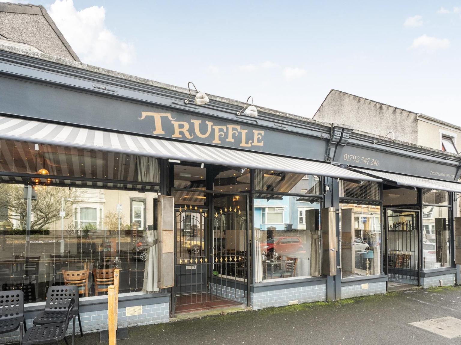 The exterior of Truffle restaurant on King Edwards Road in Uplands, Swansea, showing the distinctive striped awning and gold lettering