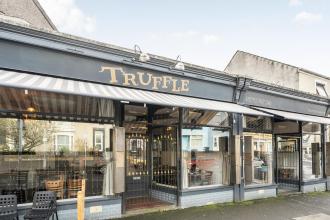 The exterior of Truffle restaurant on King Edwards Road in Uplands, Swansea, showing the distinctive striped awning and gold lettering