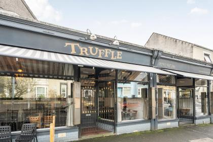 The exterior of Truffle restaurant on King Edwards Road in Uplands, Swansea, showing the distinctive striped awning and gold lettering