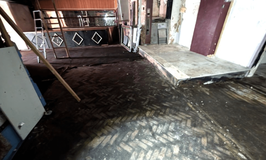 Abandoned interior of Katz nightclub Neath showing original parquet dancefloor and bar with diamond pattern detail