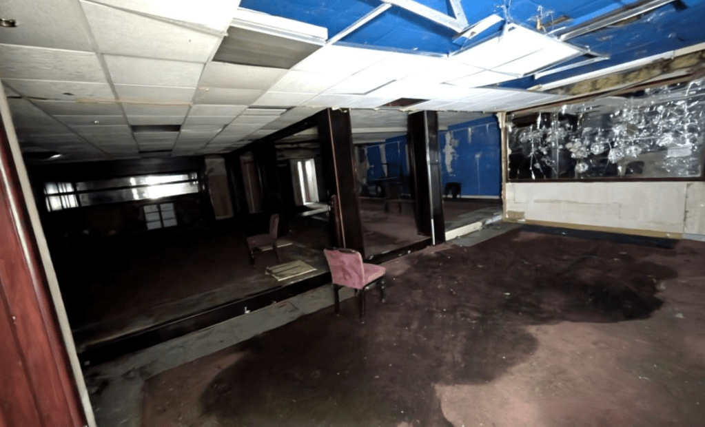 Derelict first floor bar area inside former Katz nightclub Neath with mirrored wall panels