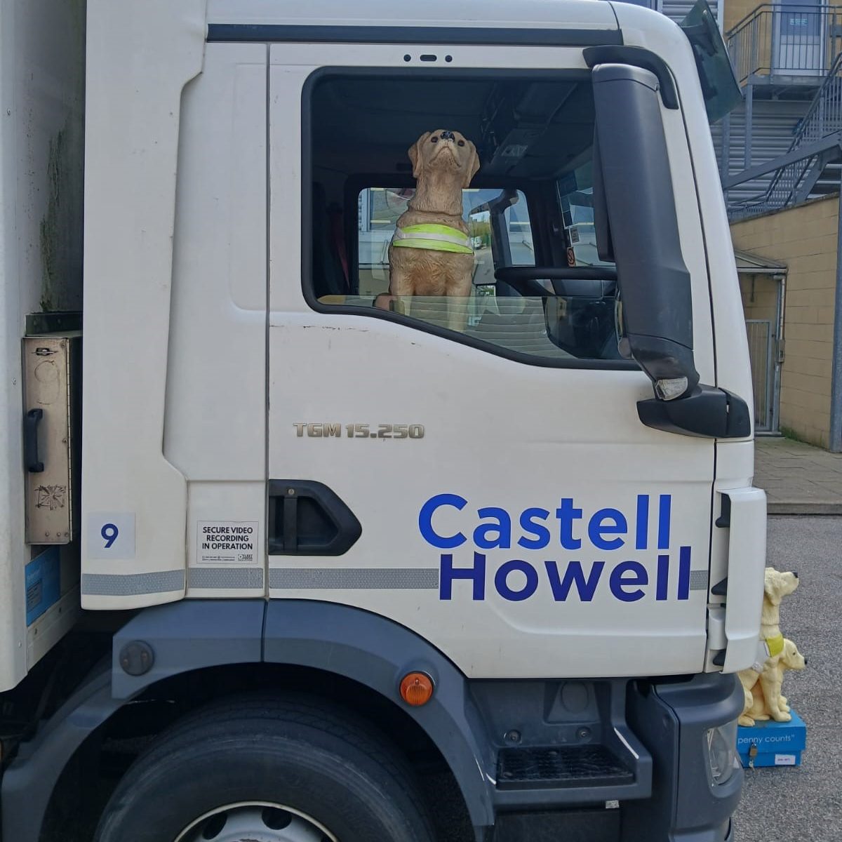 A Guide Dogs collecting box hitches a ride in the Castell Howell lorry cab on its 220-mile journey from near Wigan to South Wales. Image: Castell Howell / Guide Dogs