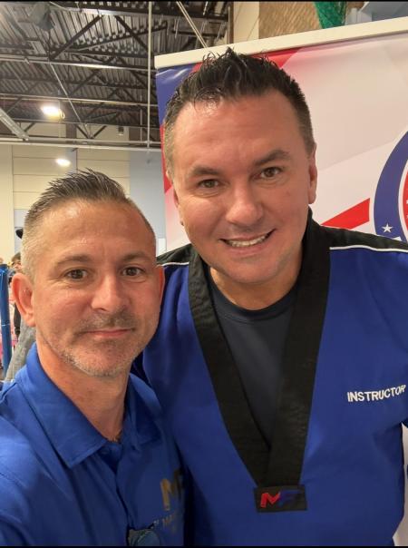 Lee Howell and Matt Fiddes pictured together at a martial arts championship, both wearing MF Martial Arts branded clothing