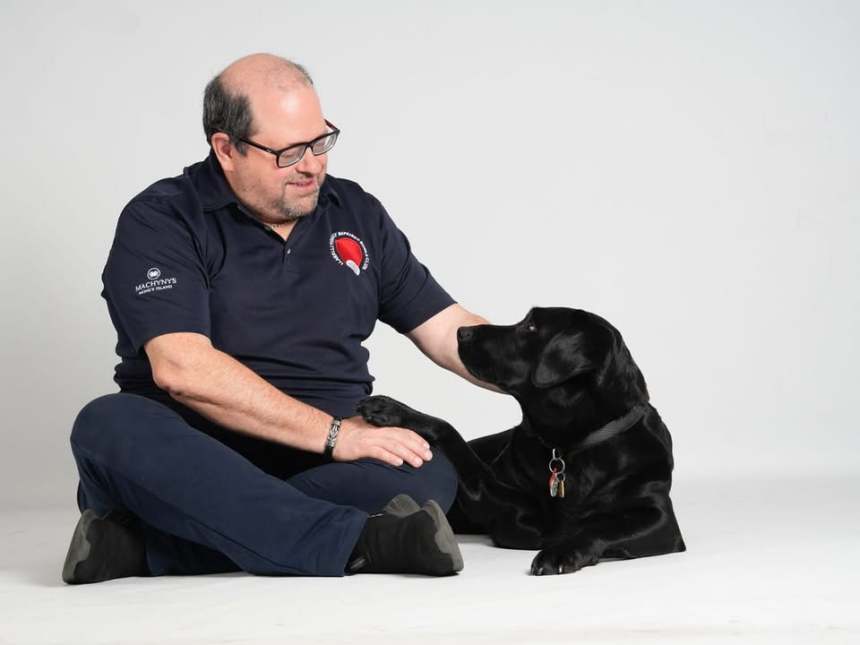 Andrew Windsor, a member of Llanelli Photographic Society with sight loss, pictured with his black labrador guide dog Lilly