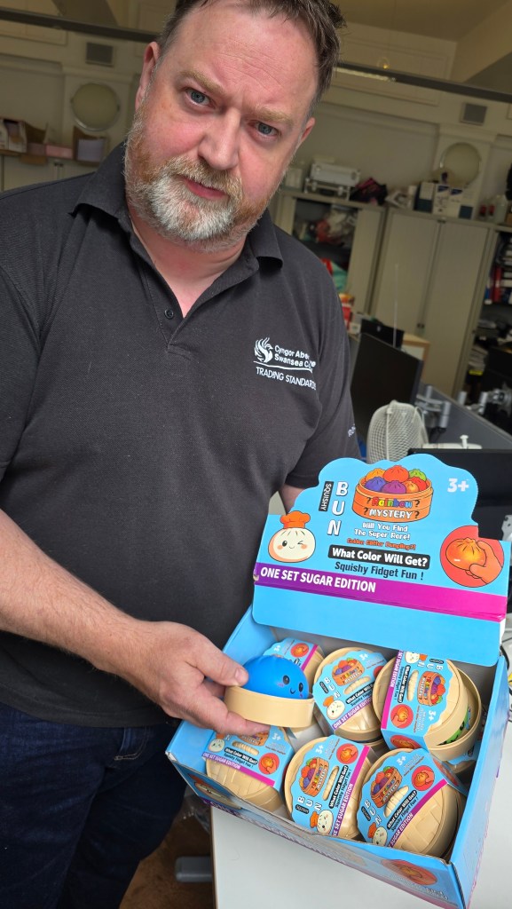Swansea Council Trading Standards Officer Rhys Harries holds a box of squishy dumpling toys that were seized from retailers in Swansea after failing basic safety requirements.