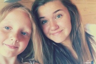 A selfie of two young girls smiling at the camera — Lexi May Hopkin on the left with blonde hair and blue eyes, and a younger Tallulah Chalstrey on the right with longer brown hair.