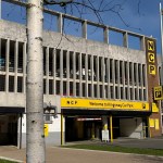 A close-up of the NCP Kingsway Car Park entrance in Swansea, showing the yellow NCP signage and Kingsway Car Park fascia with cars visible on the upper levels