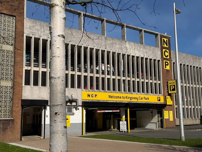 A close-up of the NCP Kingsway Car Park entrance in Swansea, showing the yellow NCP signage and Kingsway Car Park fascia with cars visible on the upper levels