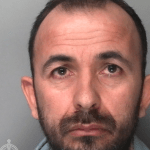 Custody photograph of Antonjo Kodheli, a middle-aged white man with dark hair and a beard, from South Wales Police