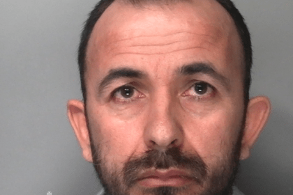 Custody photograph of Antonjo Kodheli, a middle-aged white man with dark hair and a beard, from South Wales Police