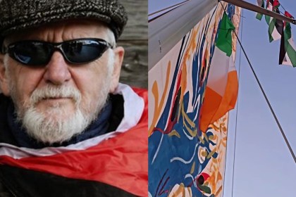 A portrait of Martin Guilfoyle, an older man with a white beard wearing a flat cap and sunglasses, alongside Irish and Palestinian flags flying from the mast of a flotilla vessel against a blue sky