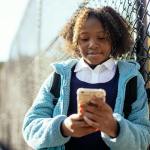 content black girl using smartphone in autumn park