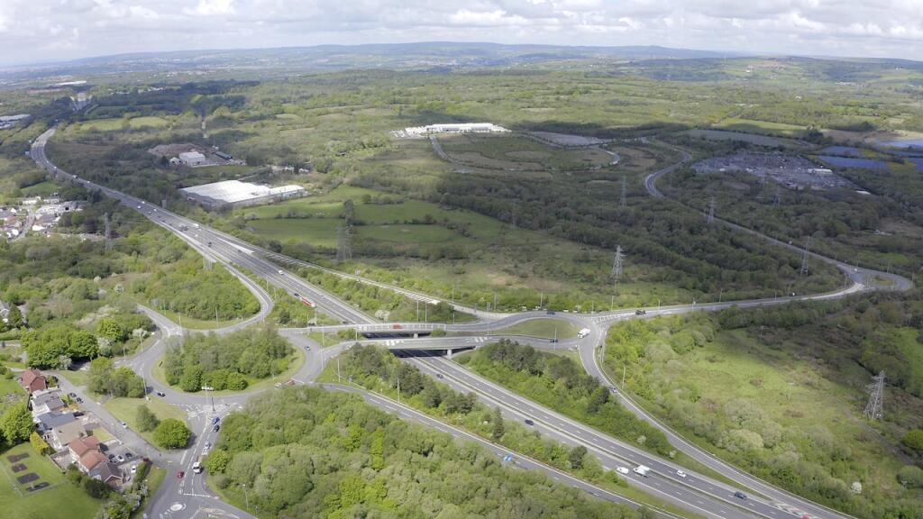Aerial view of the M4 junction 46 interchange near Swansea, with the Parc Felindre business park and surrounding countryside in the distance.