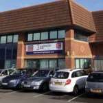 A two-storey brick office building at Sandringham Park, Swansea Vale, with cars parked outside and a "3 Sandringham Park" sign on the front.