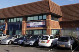 A two-storey brick office building at Sandringham Park, Swansea Vale, with cars parked outside and a "3 Sandringham Park" sign on the front.