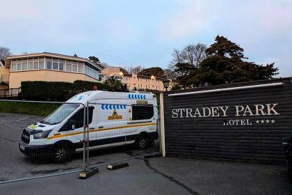 A white security van parked behind metal fencing beside a sign reading "Stradey Park Hotel", with the closed hotel buildings behind