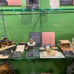A museum display case showing primary school pupils' ancient Egypt projects — a Lego sphinx and pyramid, a decorated canopic jar, a cardboard sarcophagus and handmade amulets — beside a Terrace Road Primary School information panel.