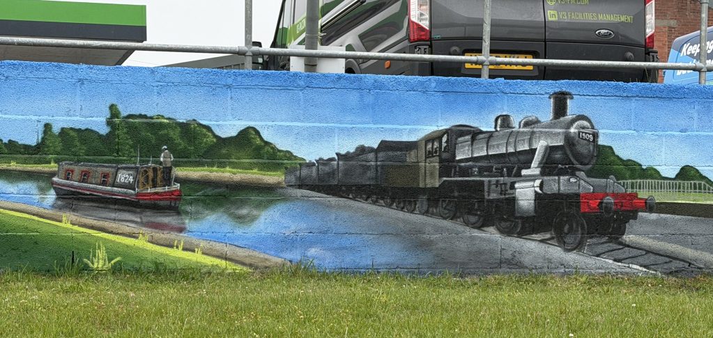 Mural detail of a canal narrowboat beside a steam locomotive hauling coal wagons.