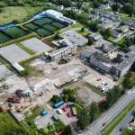 Drone view of the partly demolished former Daniel James school in Mynydd-bach, Swansea, with rubble, diggers and surrounding housing.