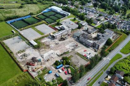 Drone view of the partly demolished former Daniel James school in Mynydd-bach, Swansea, with rubble, diggers and surrounding housing.