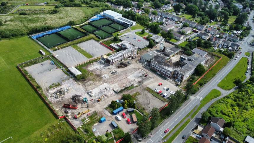 Drone view of the partly demolished former Daniel James school in Mynydd-bach, Swansea, with rubble, diggers and surrounding housing.