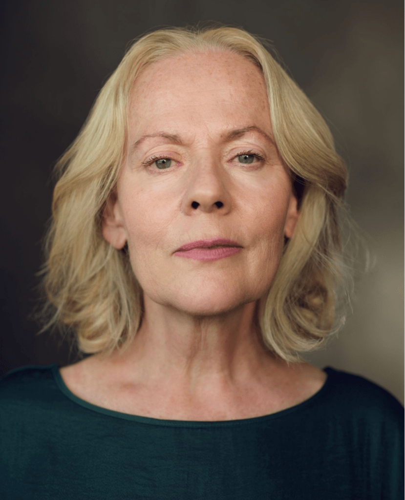 A headshot of a blonde woman looking straight at the camera.