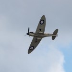 A Supermarine Spitfire of the Battle of Britain Memorial Flight banking against a cloudy sky, RAF roundels visible on its wings.