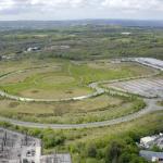Aerial view of Parc Felindre business park near Swansea, with looping internal roads, empty green plots, an electricity substation and a single large distribution centre.