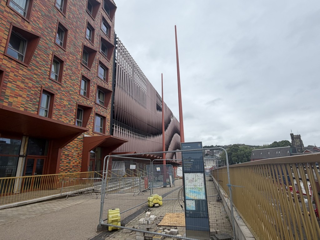 Curved glass frontage of vacant retail units at the base of the Copr Bay car park.