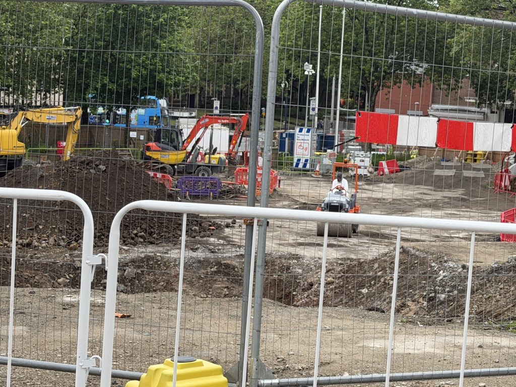 Construction diggers and a roller working on the bare ground of the former Castle Square.