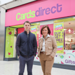 Adam Gibbons and Jane Rice standing outside the new Cards Direct store in the Quadrant Shopping Centre, with its pink shopfront and opening offer posters