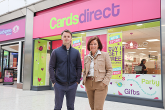 Adam Gibbons and Jane Rice standing outside the new Cards Direct store in the Quadrant Shopping Centre, with its pink shopfront and opening offer posters