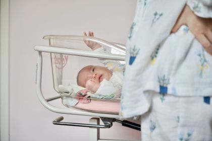a newborn baby lying in a hospital infant bassinet