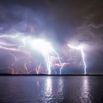 spectacular lightning storm over a river at night