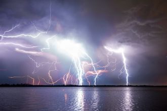 spectacular lightning storm over a river at night