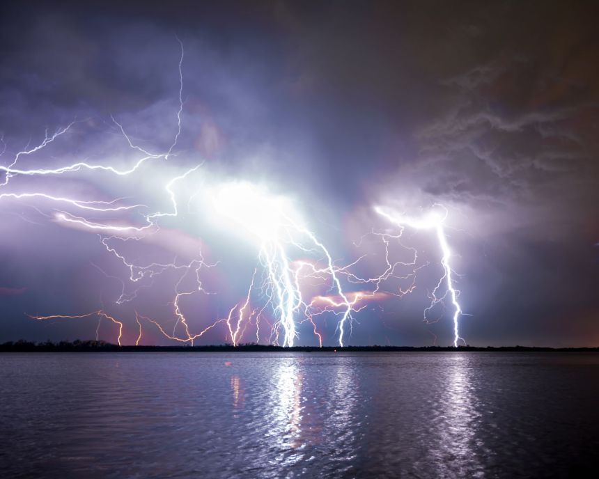 spectacular lightning storm over a river at night