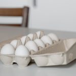 a tray of white eggs on white table